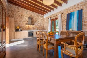 cocina y comedor con mesa de madera y sillas en Can Pere Rapinya, en Algaida