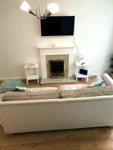 sala de estar con sofá y chimenea en (KB45) Cosy & quaint 2 bed house. Pet friendly. en Roffey