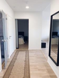 um corredor com um espelho e um quarto com uma cama em Moderni huoneisto Salon keskustassa em Salo