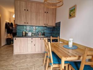 een keuken met een houten tafel en houten kasten bij Apartament Gaja in Poddąbie