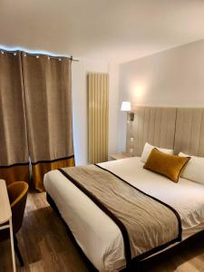 a bedroom with a large bed and a window at Hôtel Derby Eiffel in Paris