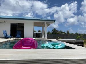 a swimming pool with two inflatable boats in it at Bungalow Sweet escape in Fare