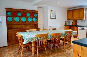a kitchen with a table and chairs in a kitchen at Rural Farmhouse on Kintyre, West Coast hidden gem in Kildalloig