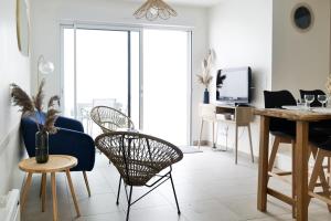 a living room with a blue chair and a table at Jolie maison rénovée dans le centre-ville avec garage privatif Les Sables 4 personnes in Les Sables-dʼOlonne