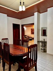 a dining room with a wooden table and chairs at Inshuti Home Stay in Gasanze