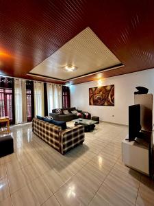 uma grande sala de estar com sofás e uma televisão em Inshuti Home Stay 