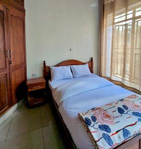 um quarto com uma cama e uma janela em Inshuti Home Stay 