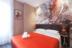a bedroom with a red bed with a painting on the wall at Town House Roma in Rome
