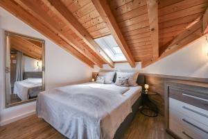 a bedroom with a large bed and a mirror at Chalet im Haus Schlossblick in Füssen