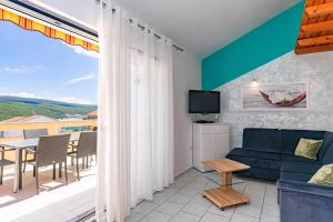a living room with a couch and a tv and a balcony at Diego in Kornić