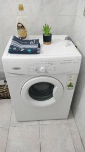 uma máquina de lavar roupa branca com uma planta em cima em Sant'Elena apartment Self check-in em Quartu SantʼElena