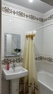 a bathroom with a sink and a shower curtain at Квартира в Туркестане in Tridtsatʼ Let Kazakhstana