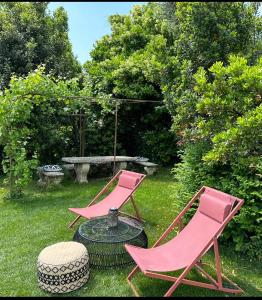 two pink chairs and a table in a yard at Relais Villa dei Gelsi & Spa in Verona