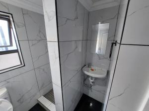 a white bathroom with a sink and a toilet at Freedommedia guesthouse in Gqeberha +2 photos