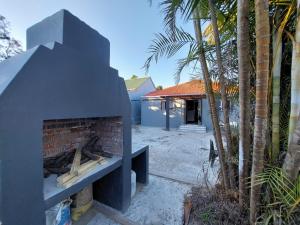 a brick fireplace in front of a house at Freedommedia guesthouse in Gqeberha