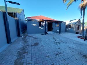a brick driveway in front of a building at Freedommedia guesthouse in Gqeberha