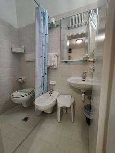 a bathroom with a sink and a toilet and a sink at Hotel Villa Lina in Riccione