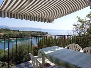 a table and chairs on a balcony with a view of the ocean at Apartmani Marina in Labin