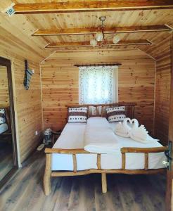 a bedroom with a bed in a log cabin at Casa de vacanță in Orlat