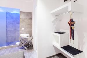 a small white room with an umbrella and a chair at Town House Roma in Rome +34 photos