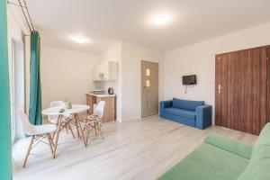 sala de estar con sofá azul y mesa en Nadmorski Apartament I by Holiday&Sun en Grzybowo