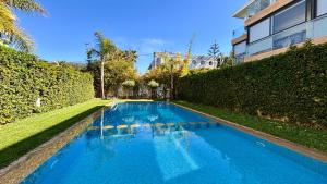 une grande piscine bleue à côté d'un bâtiment dans l'établissement Luxury garden loft tamaris, à Tamaris