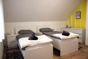 two twin beds in a room with yellow and white at Kuća za odmor Sunset in Daruvar