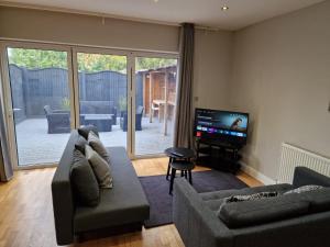 a living room with two couches and a flat screen tv at New! Lovely 2 Bed Serviced Apartment with free parking in London