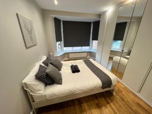 a bedroom with a bed with pillows and a mirror at New! Lovely 2 Bed Serviced Apartment with free parking in London