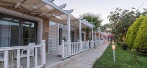 eine Veranda eines Hauses mit einem weißen Zaun in der Unterkunft KIYI SUITES Otel in Yakaköy