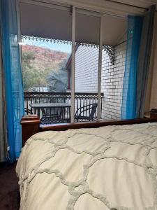 een slaapkamer met een bed en een groot raam bij Queen of the Desert Villa in Alice Springs