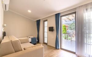 KIYI SUITES Otel في Yakaköy: غرفة معيشة مع أريكة وباب زجاجي منزلق