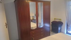 una camera da letto con un grande mobile in legno con specchio di Anabela Apartment a Carvoeiro