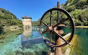 une grande roue métallique au milieu d'une masse d'eau dans l'établissement La Casetta del Vicolo, à Narni