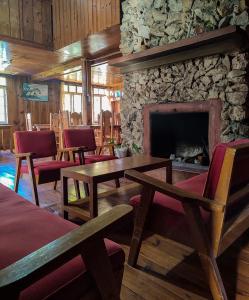 een kamer met tafels en stoelen en een stenen open haard bij Rm 207 Mhapiya-aw Pensione Inn in Sagada