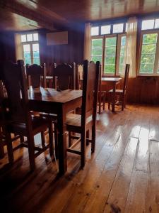 een eetkamer met een houten tafel en stoelen bij Rm 207 Mhapiya-aw Pensione Inn in Sagada