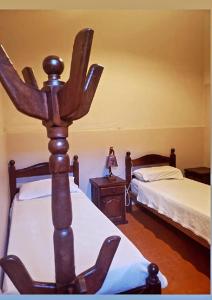 a bedroom with two beds and a woman sitting on a table at Hostal Las Carretas in San Miguel de Tucumán