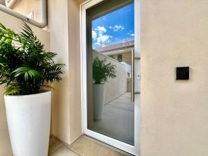 a sliding glass door with two potted plants on it at Casa Lina in Punta Secca