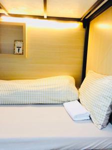 Bett mit gelben und weißen Kissen in einem Zimmer in der Unterkunft Primrose Homestay Cao Bang in Cao Bằng