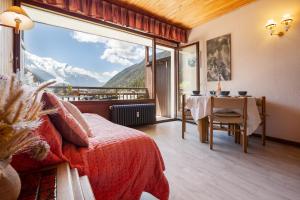 1 dormitorio con cama y mesa con vistas en Résidence Grands Montets 502 ski in-ski out - Happy Rentals, en Chamonix-Mont-Blanc