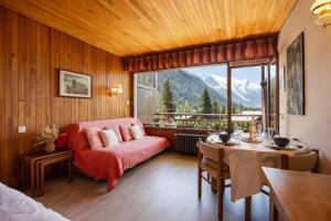 ein Schlafzimmer mit einem Sofa, einem Tisch und einem Fenster in der Unterkunft Résidence Grands Montets 502 ski in-ski out - Happy Rentals in Chamonix-Mont-Blanc