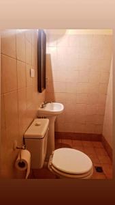 a small bathroom with a toilet and a sink at Hostal Las Carretas in San Miguel de Tucumán