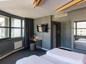 um quarto de hotel com duas camas e uma televisão de ecrã plano em B&B HOTEL Aachen City-Ost em Aachen