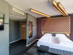 B&B HOTEL Aachen City-Ost في آخن: غرفه فندقيه بسرير ونافذه