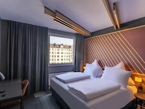 ein Hotelzimmer mit einem Bett und einem Fenster in der Unterkunft B&B HOTEL Aachen City-Ost in Aachen