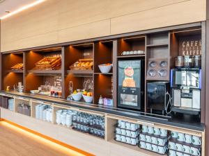 a bakery with a counter with food and drinks at B&B HOTEL Aachen City-Ost in Aachen