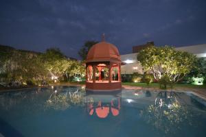 a swimming pool with a gazebo at night at The Grand Imperial - Heritage Hotel in Agra