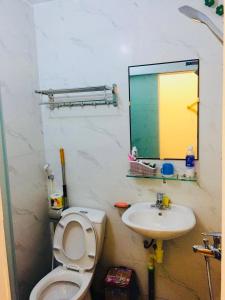 y baño con aseo, lavabo y espejo. en Primrose Homestay Cao Bang en Cao Bằng