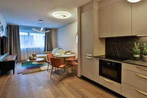 a kitchen and living room with a table and chairs at Sun Hill Luxury Suites in Budapest