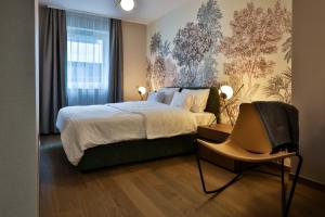 - une chambre avec un grand lit et une chaise dans l'établissement Sun Hill Luxury Suites, à Budapest